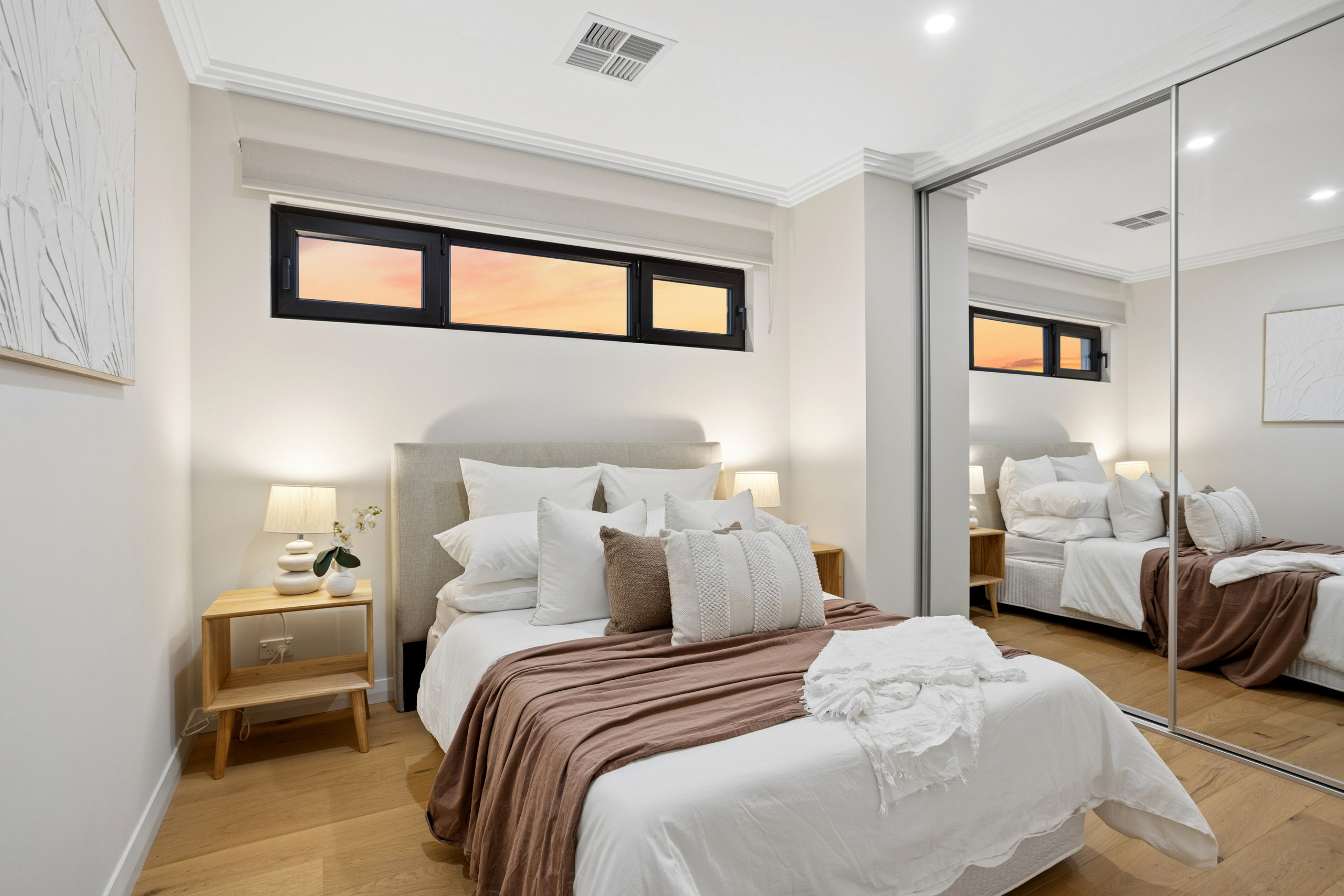 Bedroom styled in white and chocolate linen with a sunset window